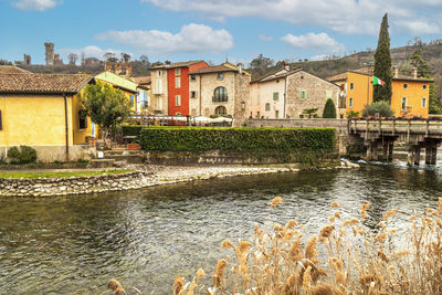  the beautiful colored houses of the hamlet of borghetto sul mincio reflecting on the water