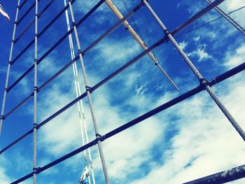 Low angle view of metal fence against sky