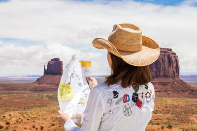 Rear view of woman holding hat