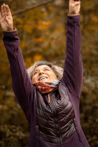 Midsection of woman with arms raised