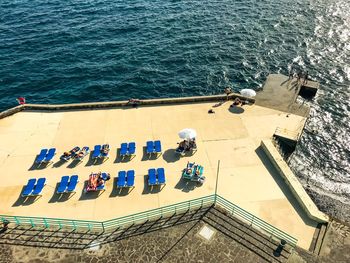 High angle view of chairs by sea