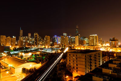 Illuminated buildings in city against sky at night