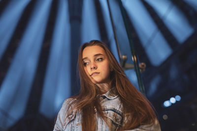 Low angle view of beautiful young woman looking away