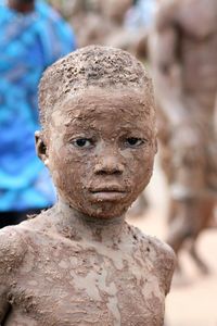 Close-up portrait of boy covered with mud