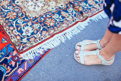 Low section of woman by carpet on road