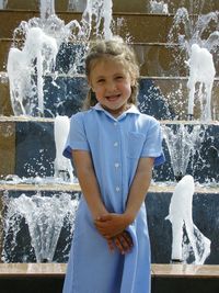 Portrait of smiling boy standing by water