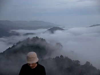 Portrait of man standing on mountain against sky