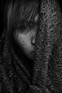 Close-up portrait of woman covering face with headscarf