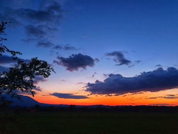 Scenic view of silhouette field against sky during sunset