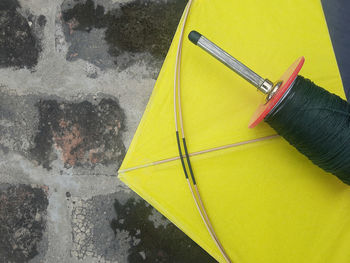High angle view of yellow umbrella on road during rainy season