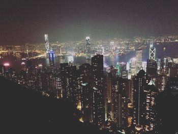 Illuminated cityscape against sky at night