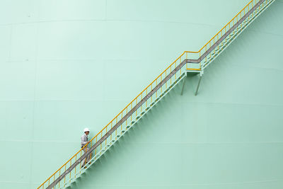 Side view of mature woman walking on steps on wall