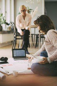 Architects working with design on the floor at home