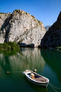 Sailboat on rock by lake against sky