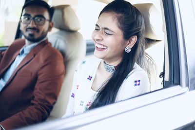 Portrait of smiling young woman sitting in car