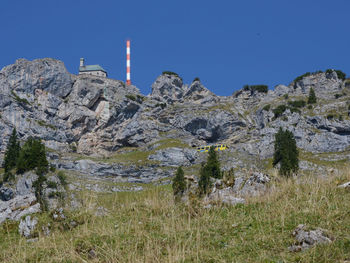 Low angle view of sternwarte wendelstein on rocky mountain against clear blue sky