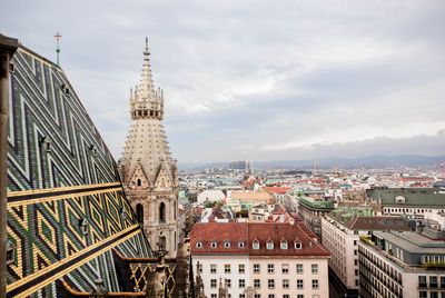 Buildings in city against cloudy sky