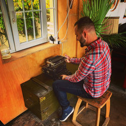 High angle view of man using typewriter at home