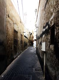 Alley amidst buildings in city against sky