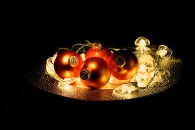 Close-up of christmas lights over black background