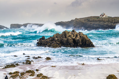 Scenic view of rocks in sea against sky