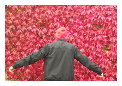 Rear view of man standing against autumn leaves