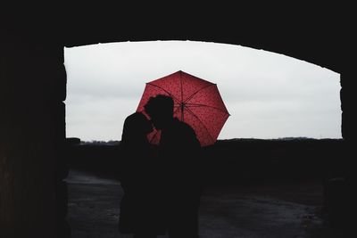 Rear view of silhouette couple standing against sky