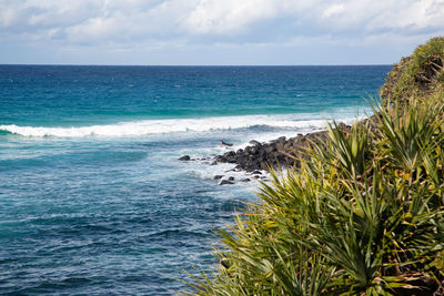 Scenic view of sea against sky with a surfer jumping