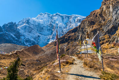 Flags and temple on mountain against sky