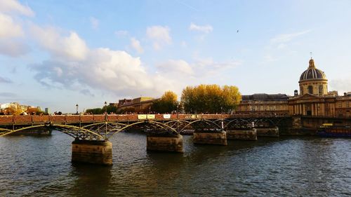 View of bridge over river against cloudy sky