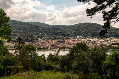 Scenic view of townscape by mountains against sky