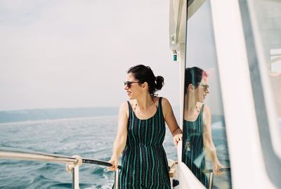 Smiling woman standing in boat