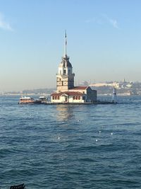 Building by sea against clear sky