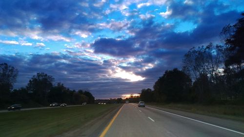 Country road against cloudy sky