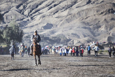 People walking on mountain against sky