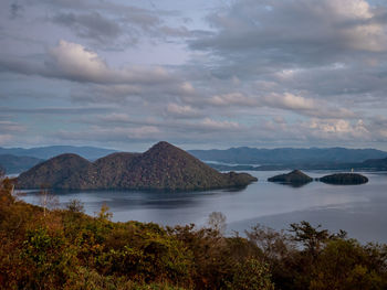 Scenic view of sea and mountains against sky