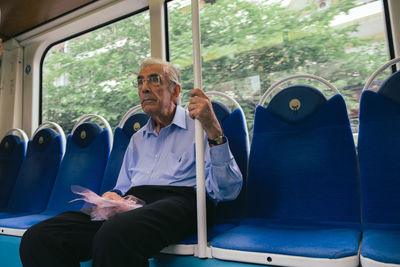 Full length of man sitting on seat