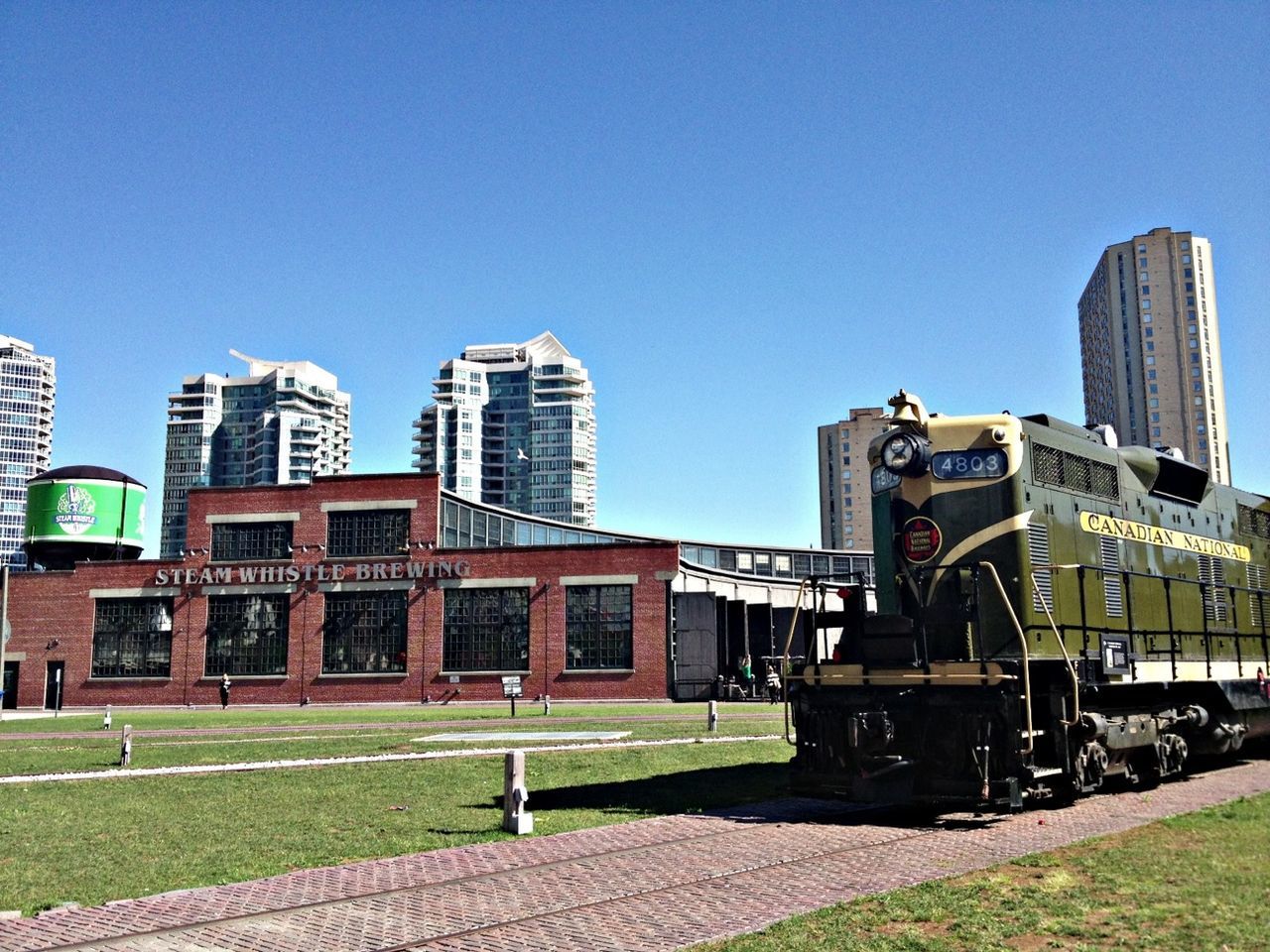 clear sky, building exterior, architecture, built structure, blue, grass, copy space, sunlight, lawn, city, day, building, outdoors, incidental people, green color, history, sky, shadow, no people, exterior