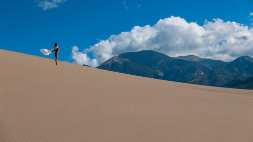 Scenic view of desert against cloudy sky