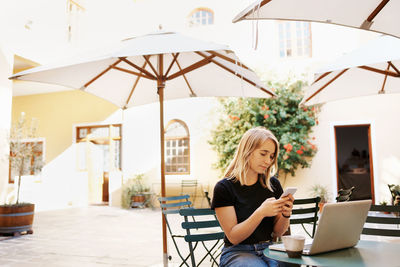 Beautiful woman using mobile phone at cafe