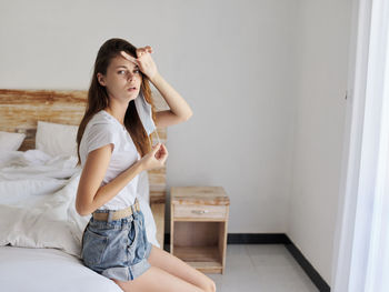 Beautiful young woman sitting at home