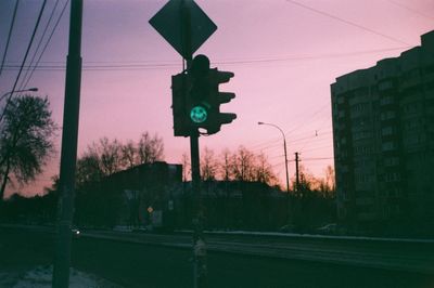 Road sign against sky at sunset