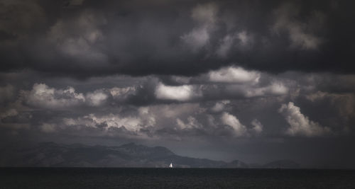 Scenic view of sea against storm clouds