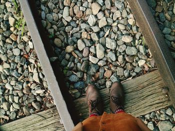 Low section of woman standing on railroad track