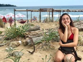 Cheerful young woman sitting at beach