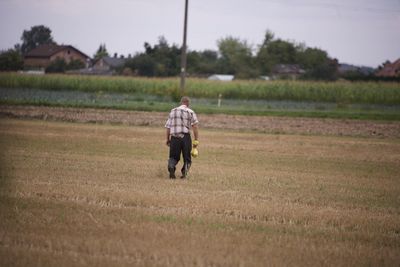 Rear view of man walking on field