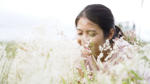 Portrait of woman with pink flowers against blurred background