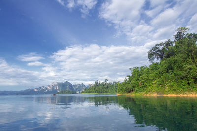 Scenic view of lake by trees against sky