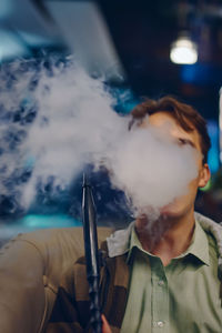 Portrait of man smoking at home