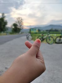 Cropped image of person hand against sky